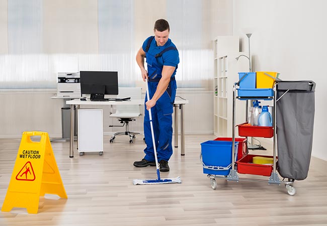 Janitor cleaning floor in office