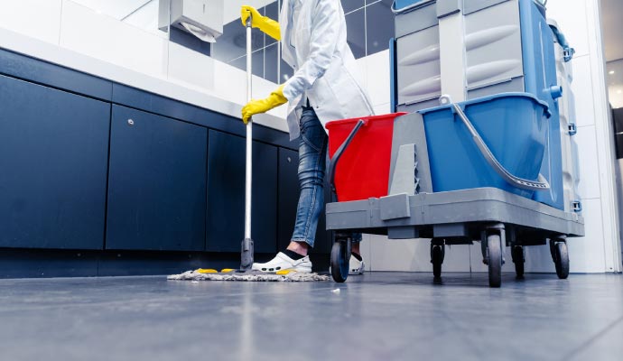 Sanitation of restroom by service provider using mop, wearing gloves