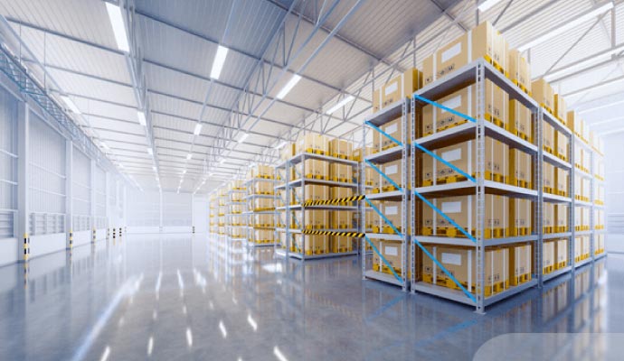 A clean and organized warehouse floor with tall racks of cardboard boxes