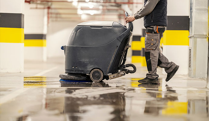 An expert cleaning a commercial garage floor