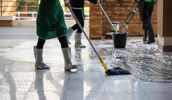 Person cleaning floor with equipment
