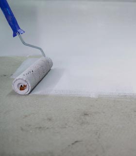 Floor coating in progress using paint roller