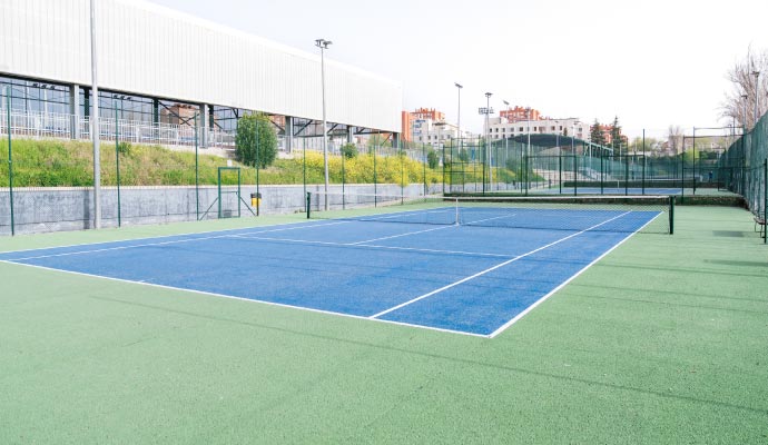 Outdoor tennis court within a sporting complex 