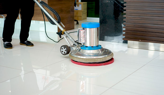 A rotary machine polishing a tile floor to a high shine.