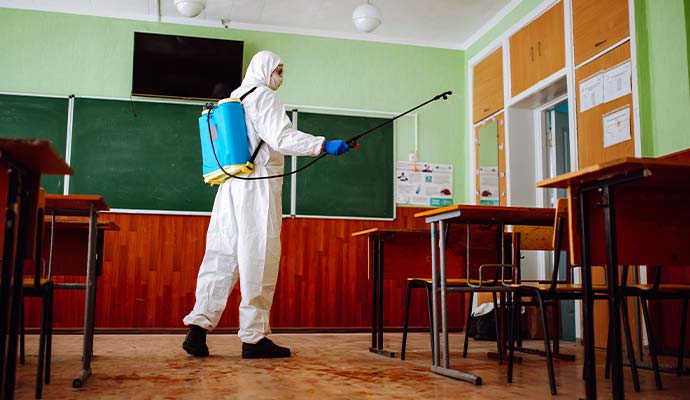 Expert disinfecting school classroom
