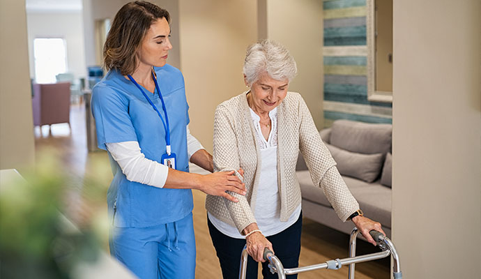 Nurse assisting senior resident with walker