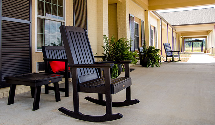 Senior living facility porch with rocking chairs