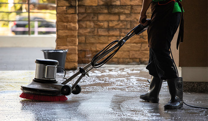 Technician cleaning floor with scrubber