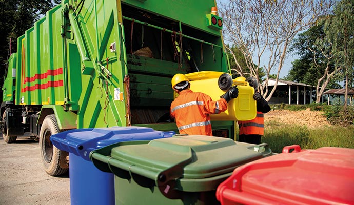 Workers loading wastes inside truck