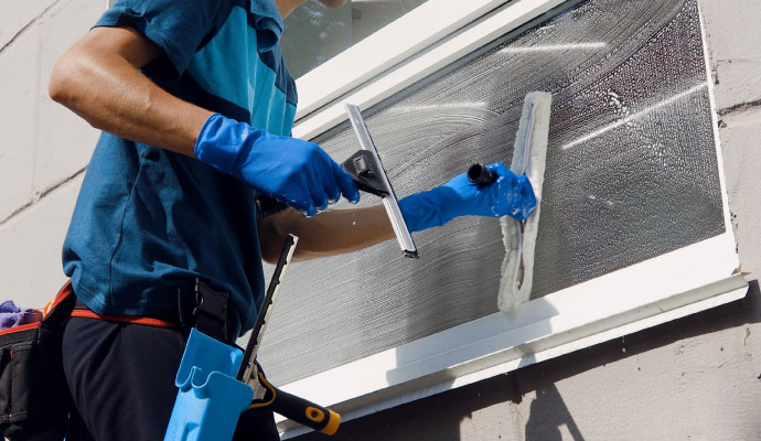 An expert cleaning an exterior window