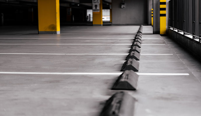 Clear white lines and safety bollards in a parking garage.