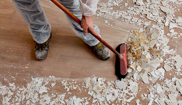 A worker sweeping up drywall debris after a renovation.