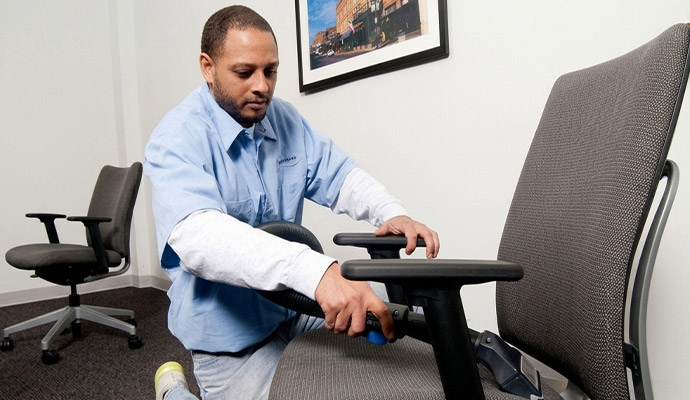 A professional of Valor Janitorial cleaning a office chair using equipment