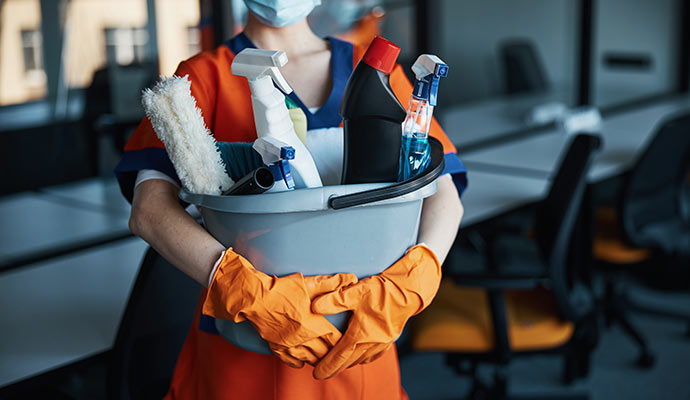 Professional worker holding janitorial supplies