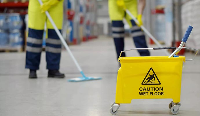 Worker cleaning the floor of the warehouse